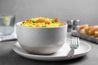 Photo of Delicious pilaf with chicken meat on light grey table