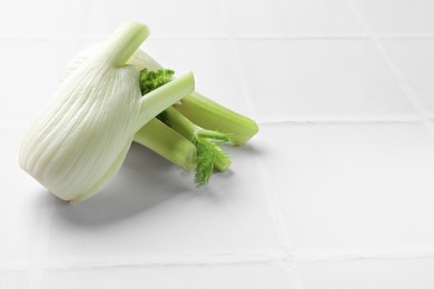Photo of Fresh raw fennel bulbs on white table. Space for text