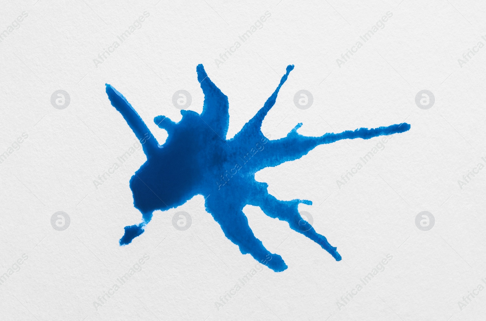 Photo of Blot of blue ink on white background, top view