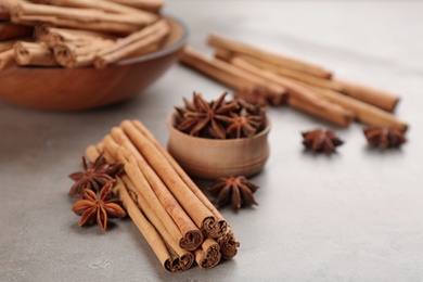 Aromatic cinnamon sticks and anise on grey table