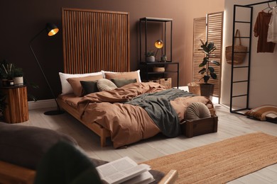 Photo of Stylish room interior with large bed near brown wall