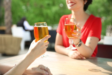 Young women with glasses of cold beer at table