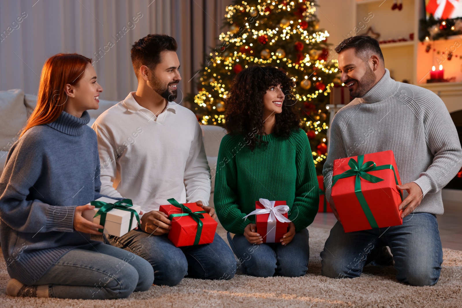 Photo of Christmas celebration. Happy friends with gift boxes at home