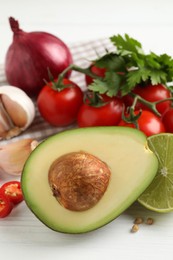Photo of Fresh ingredients for guacamole on white wooden table, closeup