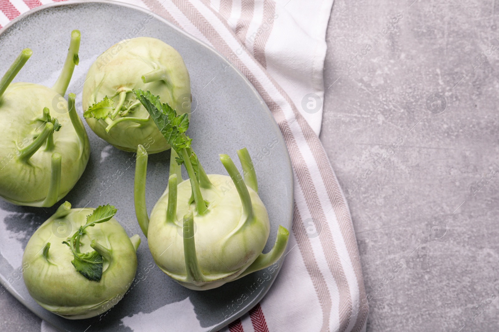 Photo of Whole ripe kohlrabi plant on grey table, top view