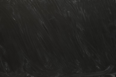 Photo of Dirty black chalkboard as background. School equipment