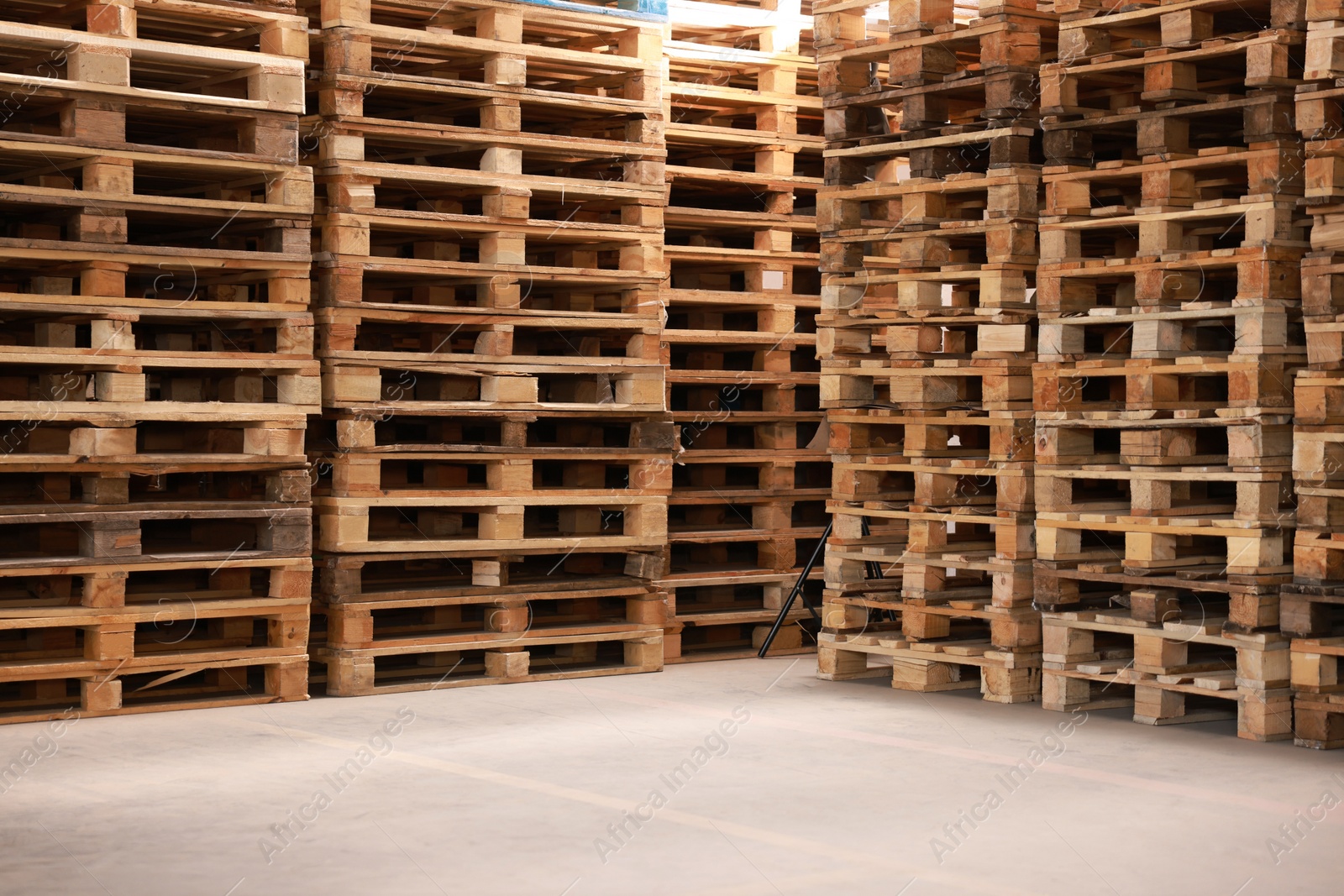 Image of Many empty wooden pallets stacked in warehouse