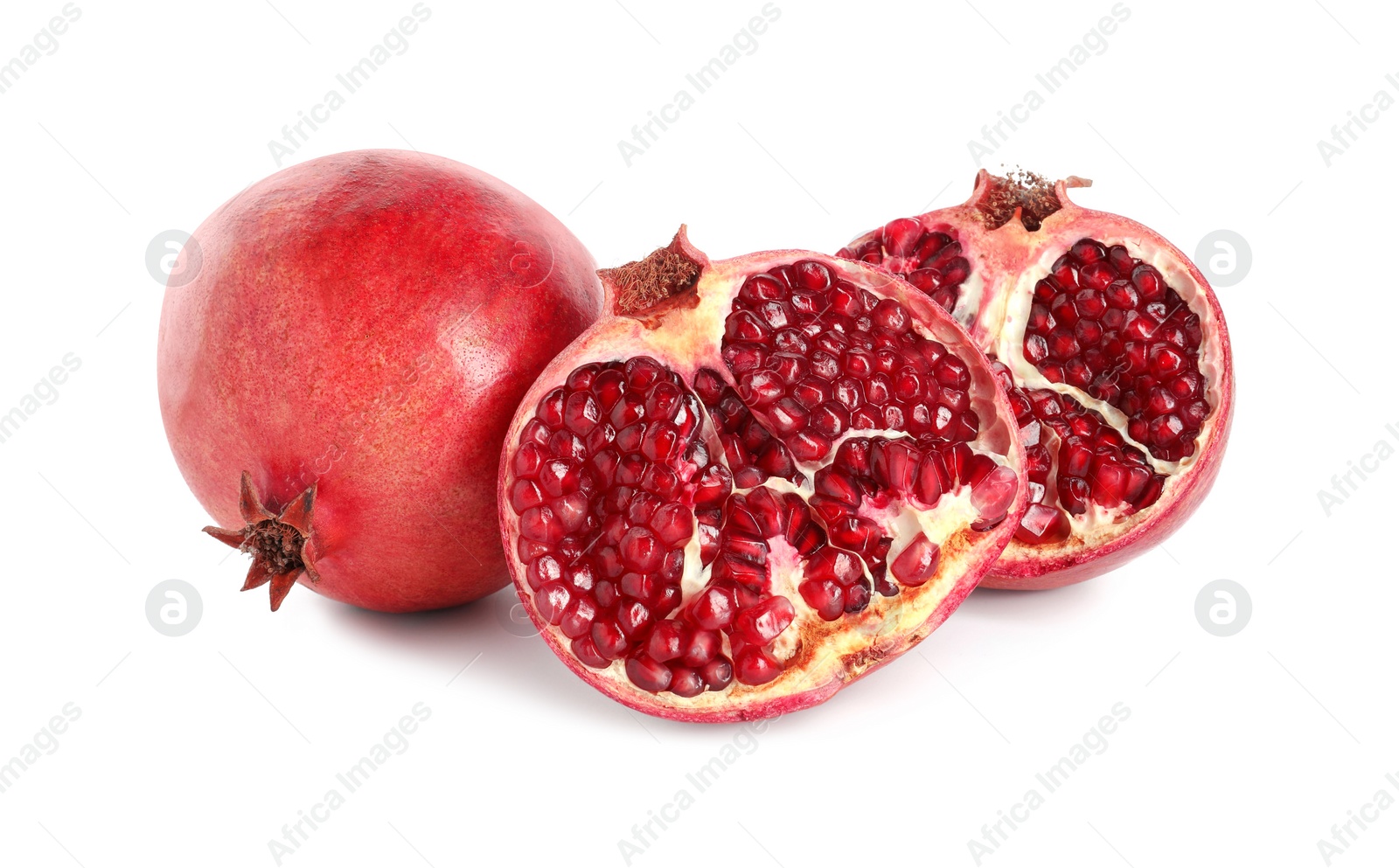 Photo of Halves and whole pomegranates isolated on white