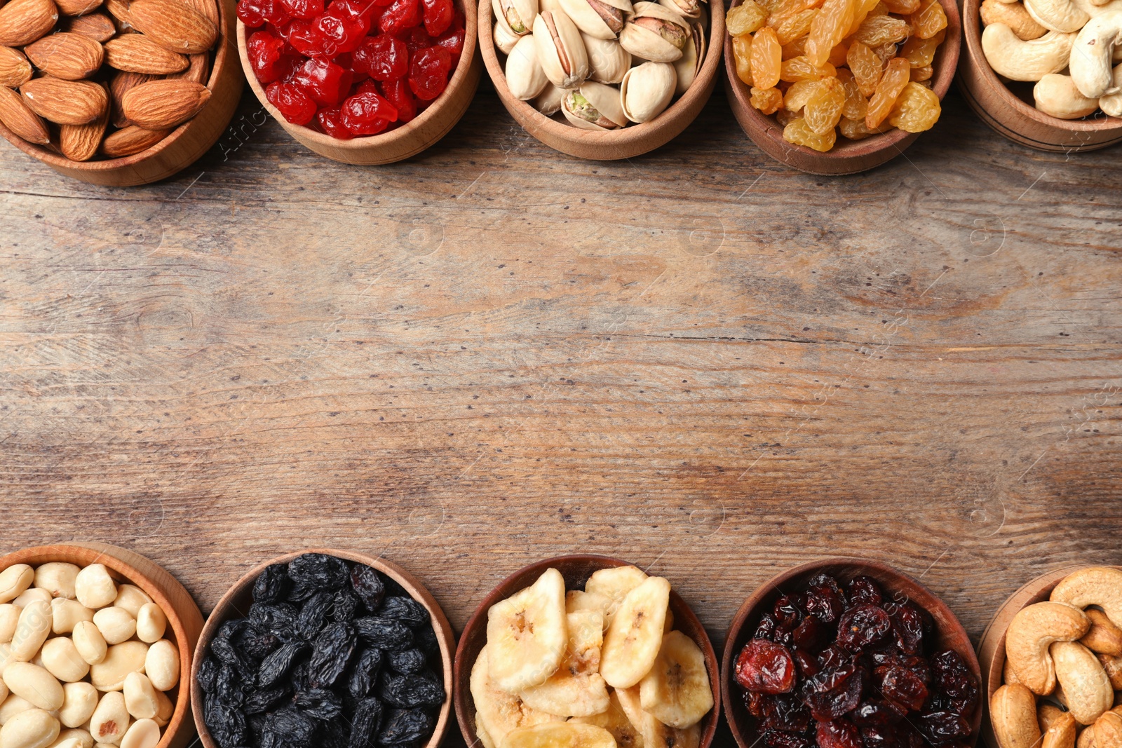 Photo of Composition of different dried fruits and nuts on wooden background, top view. Space for text