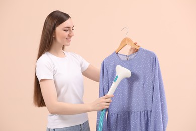 Photo of Woman steaming blouse on hanger against beige background