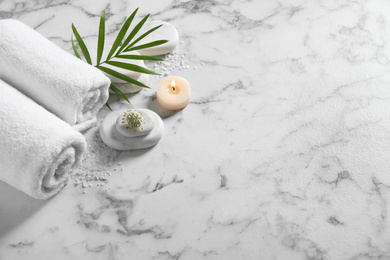 Photo of Beautiful composition with spa stones on white marble table, above view