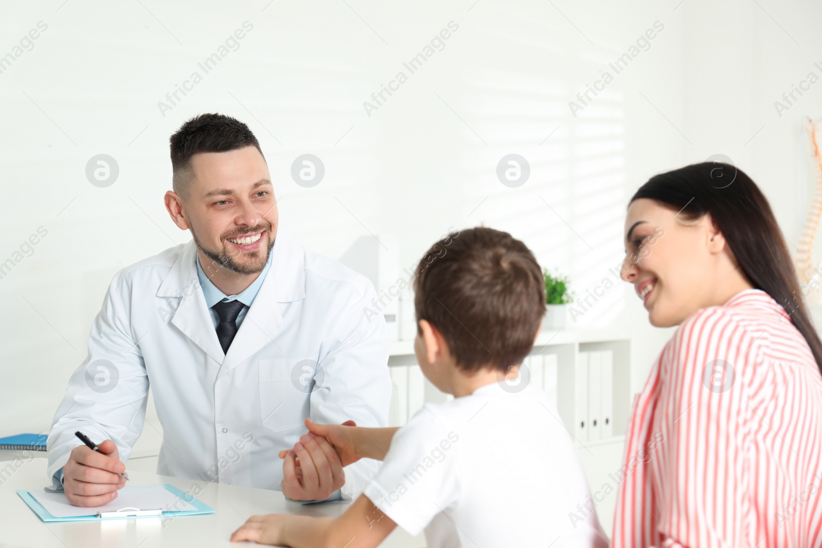 Photo of Little boy with mother visiting orthopedist at clinic