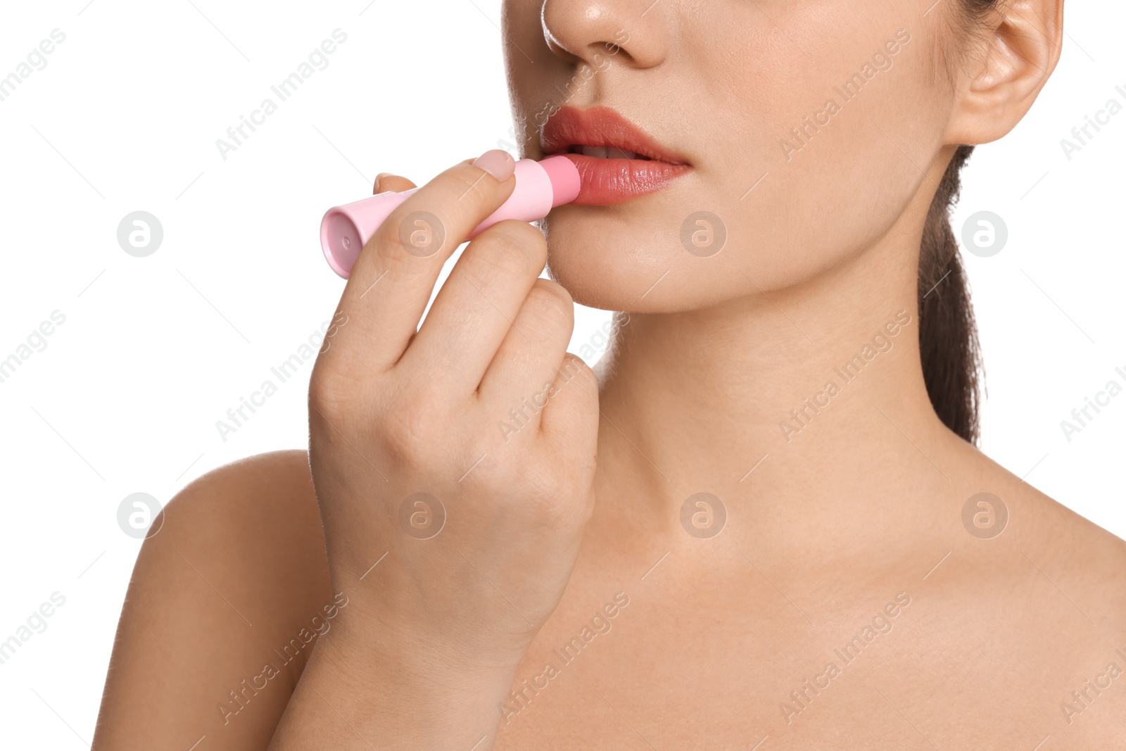 Photo of Young woman applying lip balm on white background, closeup