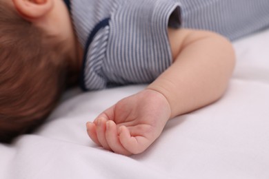 Photo of Newborn baby lying on white blanket, closeup