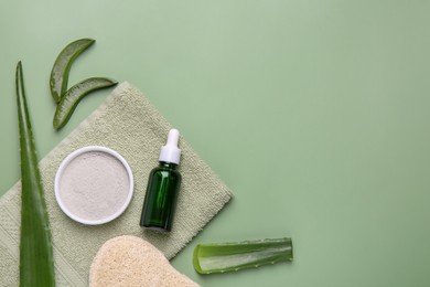 Photo of Flat lay composition with cosmetic products and cut aloe leaves on pale green background. Space for text