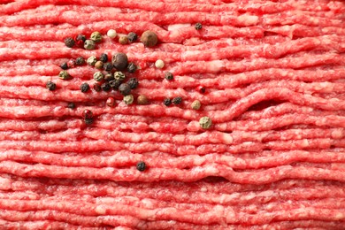 Photo of Raw ground meat and peppercorns as background, closeup