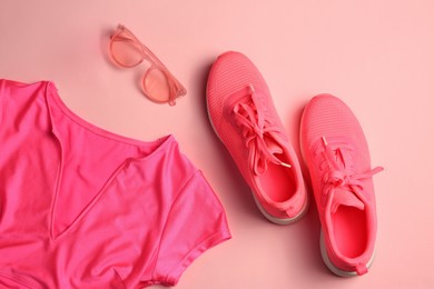 Photo of Stylish sunglasses, antiperspirant, pink sneakers and t-shirt on color background, flat lay