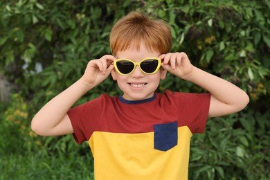 Photo of Cute little boy with sunglasses in park