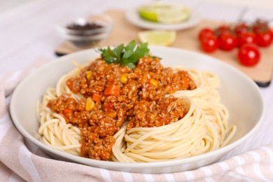 Tasty dish with fried minced meat, spaghetti, carrot and corn on white wooden table, closeup