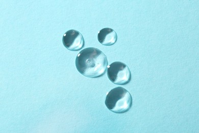 Photo of Samples of cosmetic serum on light blue background, flat lay