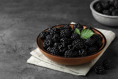 Photo of Bowl with fresh ripe blackberries on dark grey table
