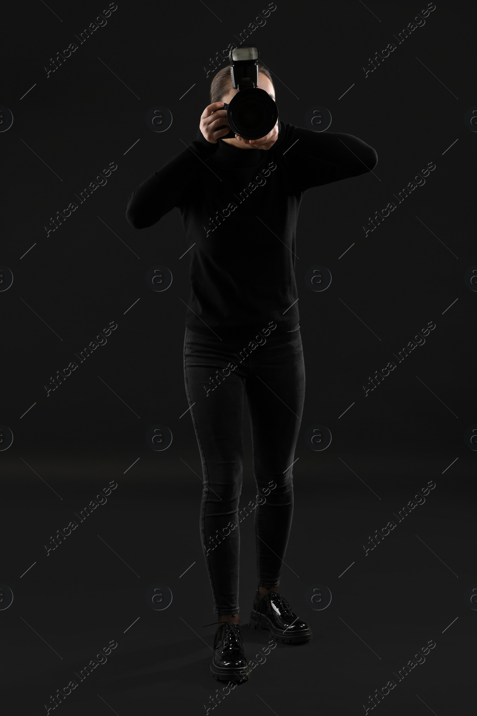 Photo of Professional photographer taking picture on black background