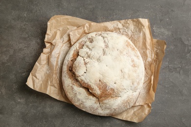 Photo of Tasty freshly baked bread on grey table, top view