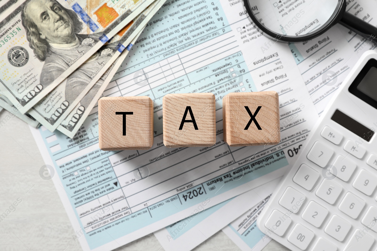 Photo of Wooden cubes with word Tax, documents, money and calculator on light table, flat lay