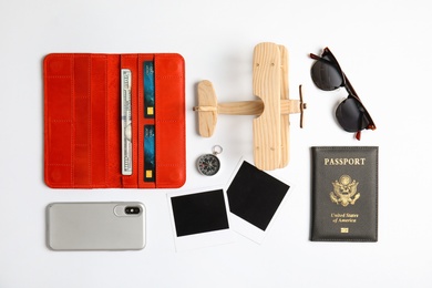 Photo of Flat lay composition with toy airplane and passport on white background. Travel agency