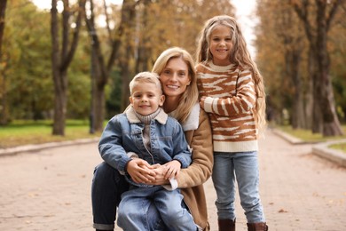 Photo of Portrait of happy mother and her children in autumn park