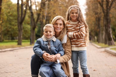 Portrait of happy mother and her children in autumn park