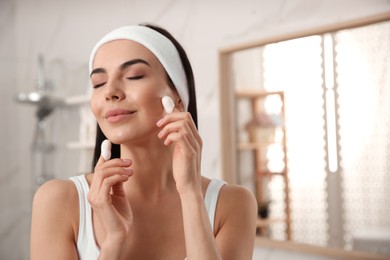 Photo of Woman using silkworm cocoons in skin care routine at home