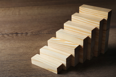 Photo of Steps made with blocks on wooden table. Career ladder