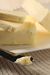 Tasty butter and knife on table, closeup