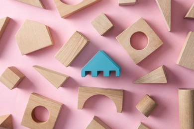 Photo of One turquoise toy building block among others on pink background, flat lay. Diversity concept