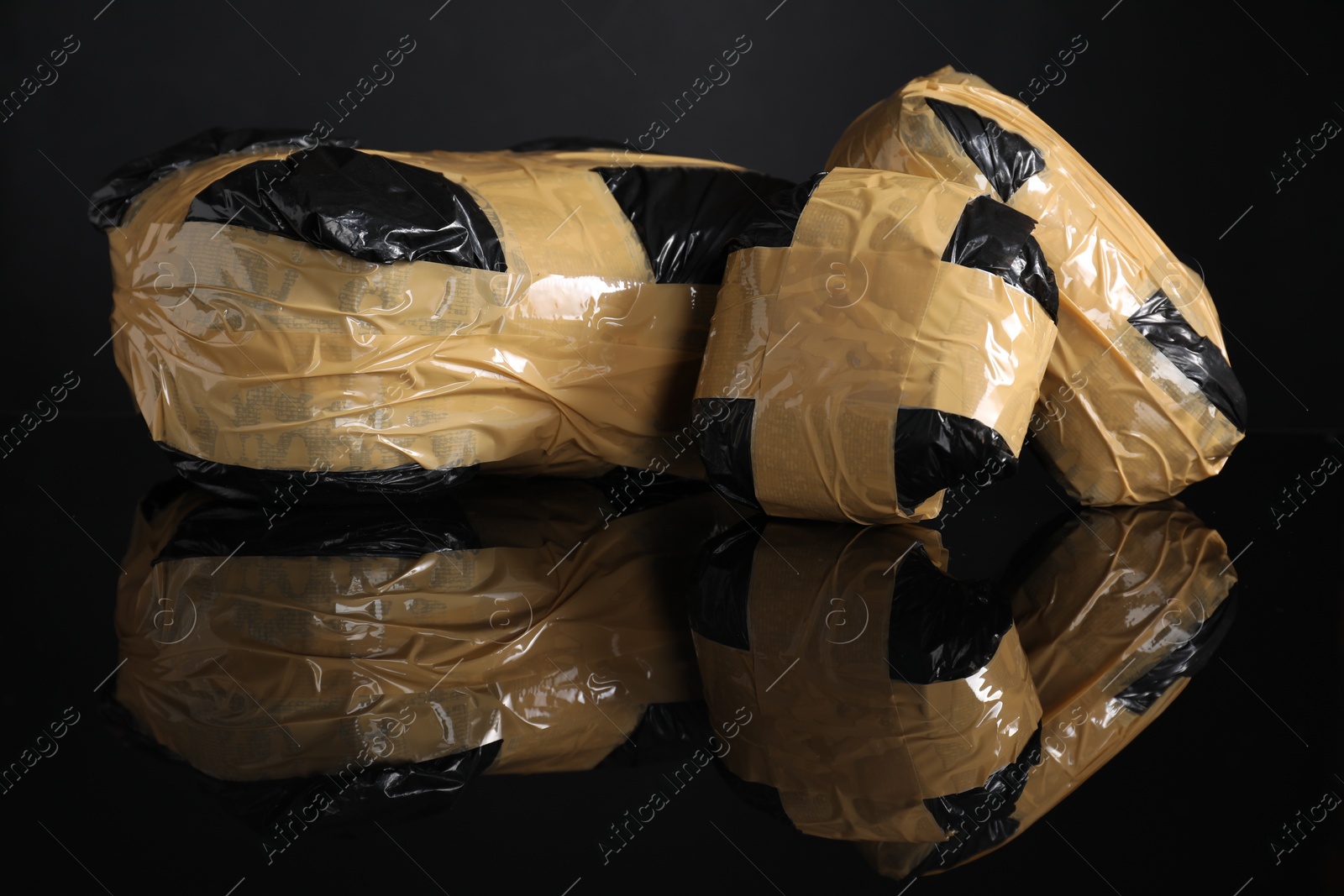 Photo of Smuggling and drug trafficking. Packages with narcotics on black mirror surface