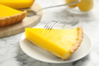 Photo of Slice of delicious homemade lemon pie on white marble table