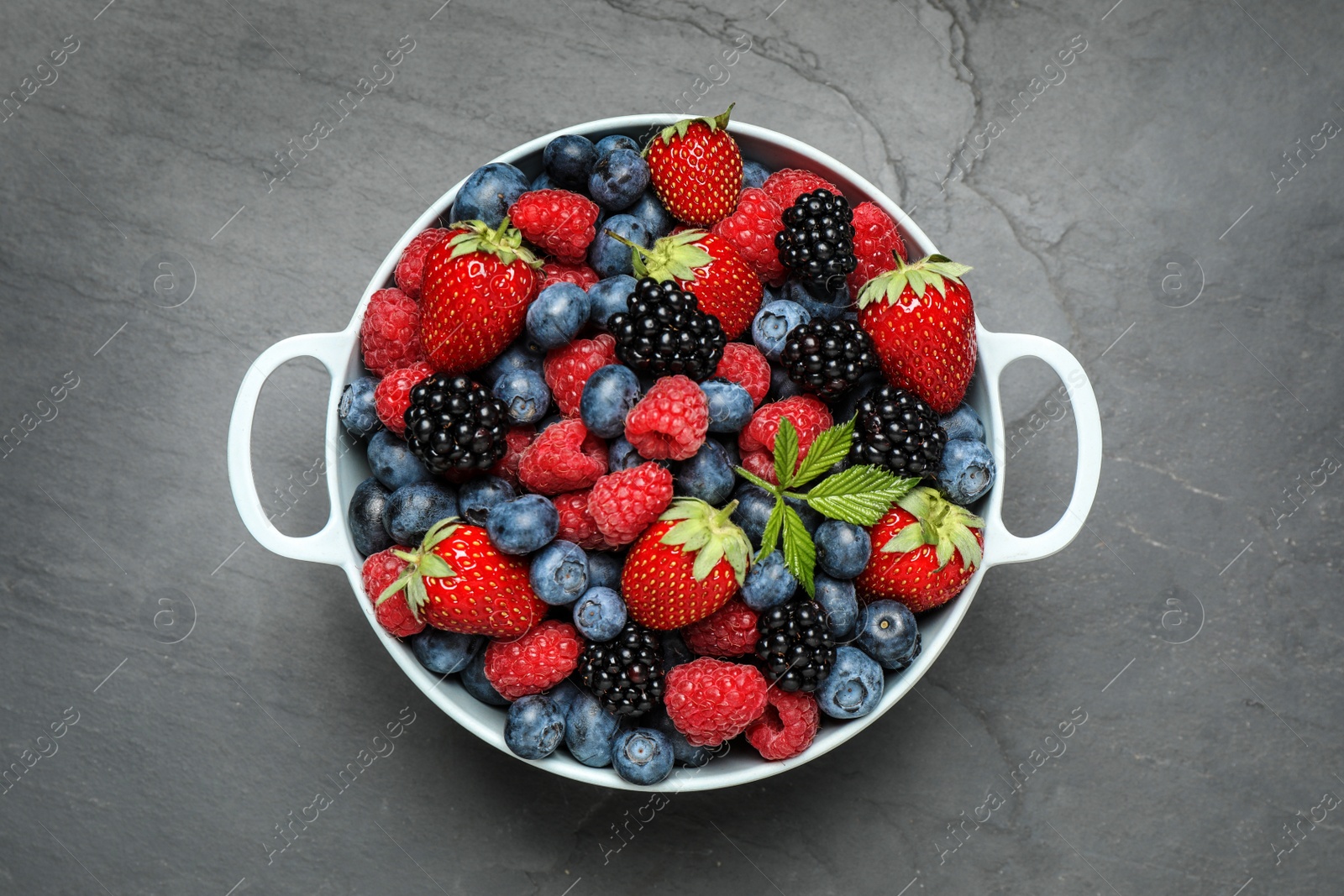 Photo of Mix of ripe berries on grey table, top view