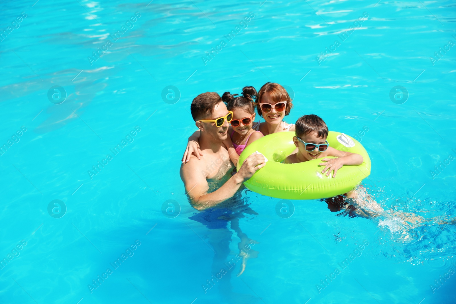 Photo of Happy family in swimming pool at resort