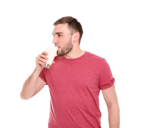 Young man drinking tasty milk on white background