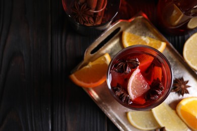 Photo of Glass of aromatic punch drink and ingredients on wooden table, flat lay. Space for text