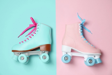 Vintage roller skates on color background, top view