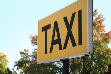 Post with Taxi sign on city street, closeup