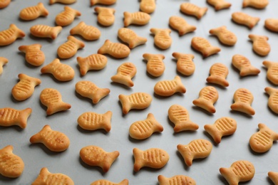 Delicious goldfish crackers on grey table, closeup