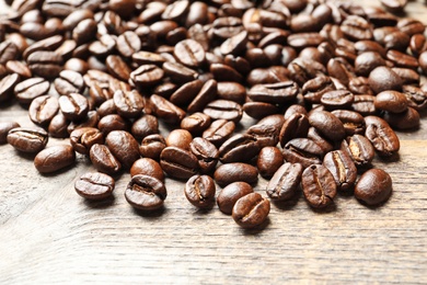 Photo of Roasted coffee beans on wooden background, closeup