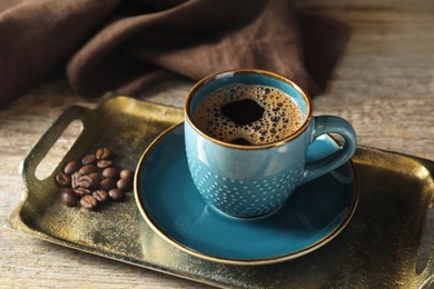 Photo of Turkish coffee. Freshly brewed beverage and beans on wooden table, closeup