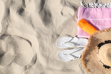 Photo of Flat lay composition with beach accessories on sand. Space for text