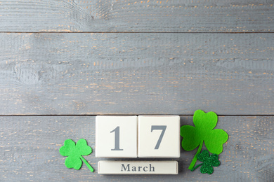 Photo of Flat lay composition with wooden block calendar on grey background, space for text. St. Patrick's Day celebration