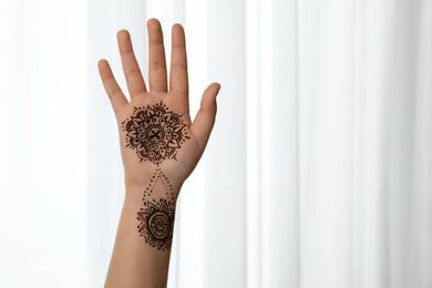 Photo of Little girl with henna tattoo on palm, closeup and space for text. Traditional mehndi ornament