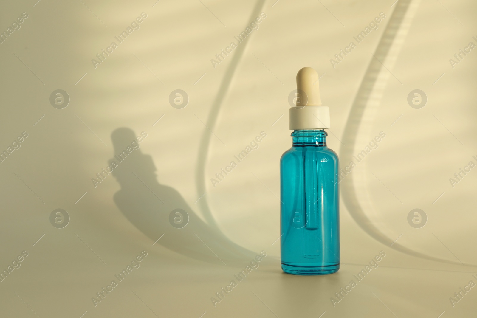 Photo of Bottle with cosmetic product on beige background, space for text